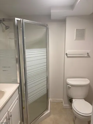 a white toilet sitting next to a shower