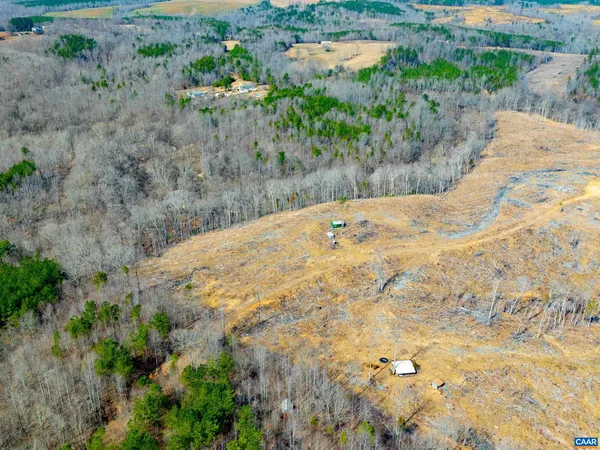 a view of a dry yard with wooden fence