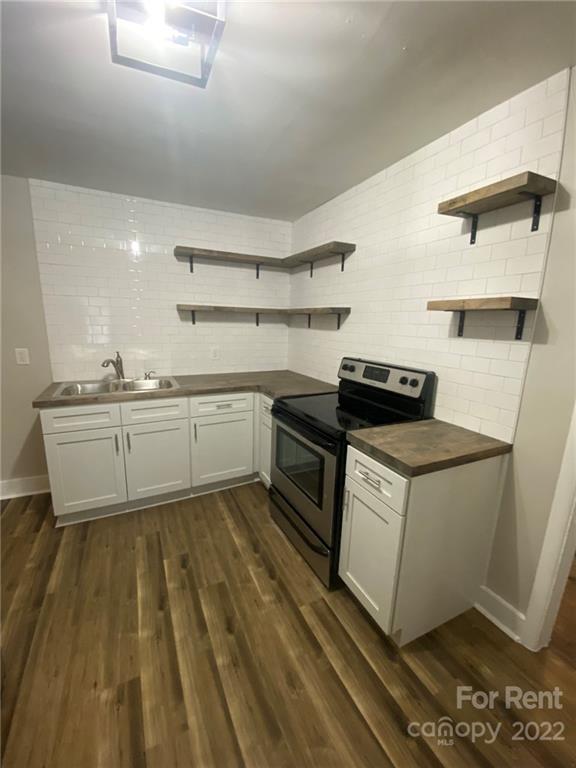 3130 Ridge Avenue Charlotte, NC 28208 - Photo 2 of 12 a kitchen with a sink a stove and cabinets