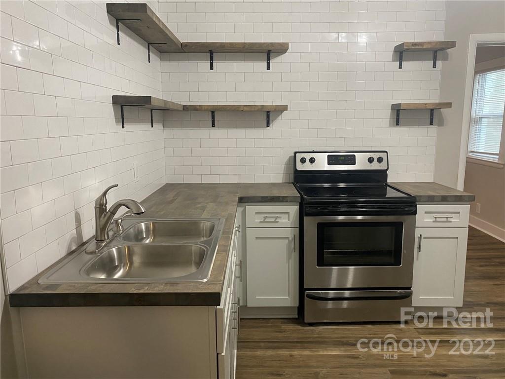 3130 Ridge Avenue Charlotte, NC 28208 - Photo 3 of 12 a kitchen with a sink stainless steel appliances and cabinets