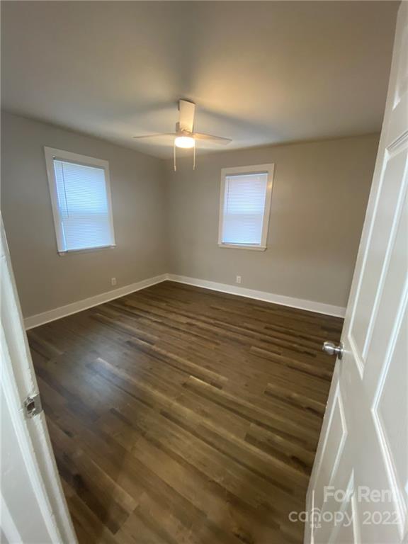 3130 Ridge Avenue Charlotte, NC 28208 - Photo 6 of 12 an empty room with wooden floor chandelier fan and windows