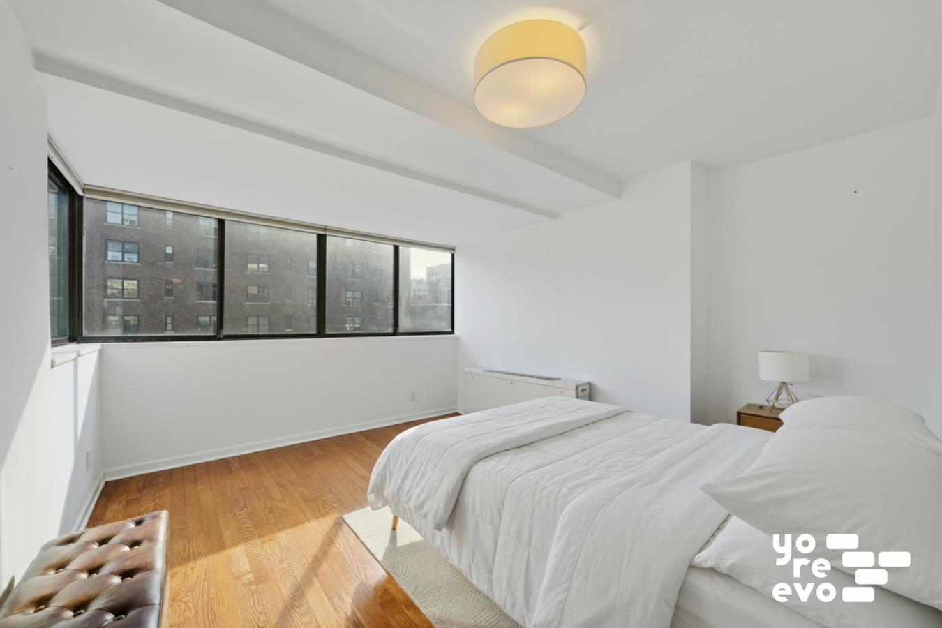 142 East 16th Street, Unit 8C Manhattan, NY 10003 - Photo 4 of 8 a bedroom with a large bed and a chandelier