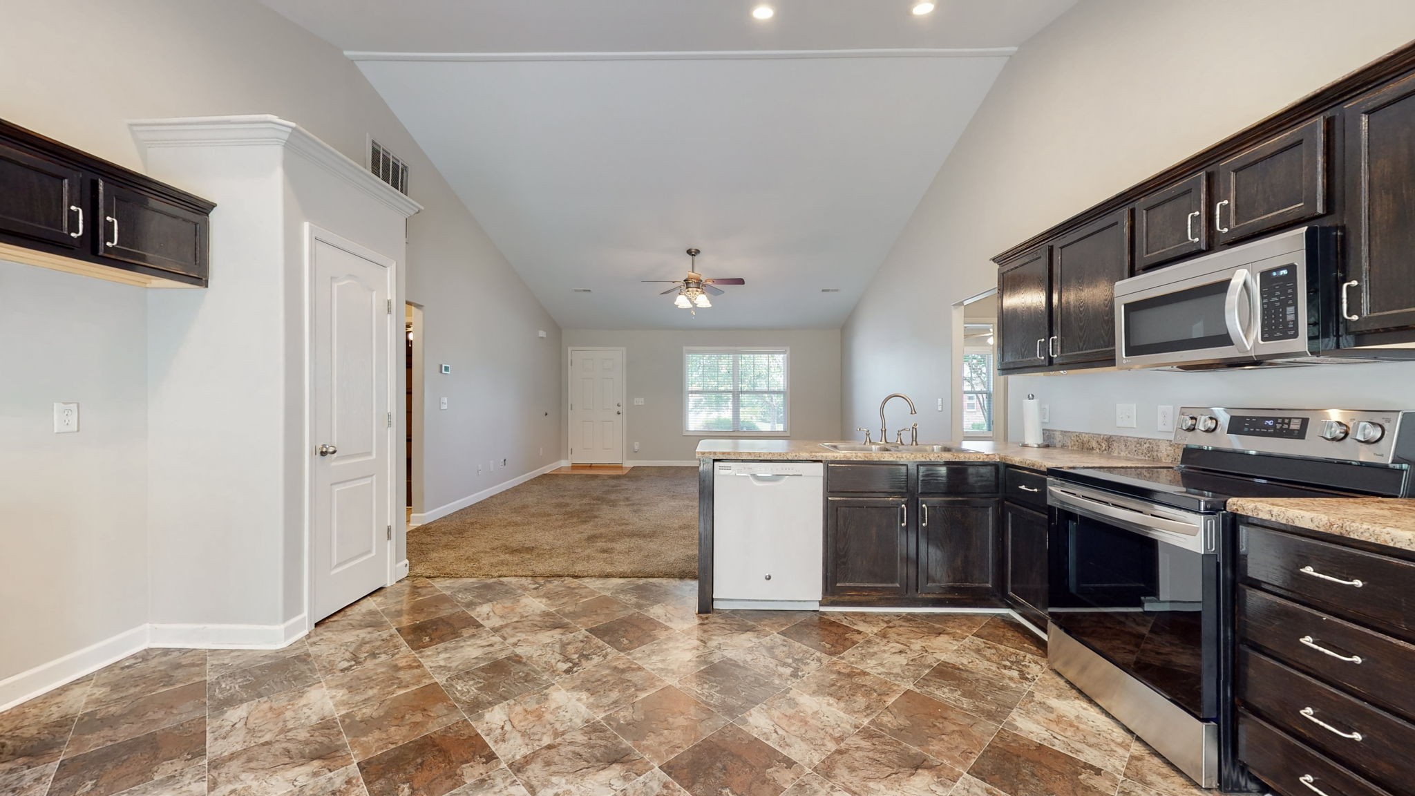 6025 Chickadee Circle Spring Hill, TN 37174 - Photo 9 of 44 a kitchen with stainless steel appliances granite countertop a stove top oven a sink dishwasher a dining table and chairs with wooden floor
