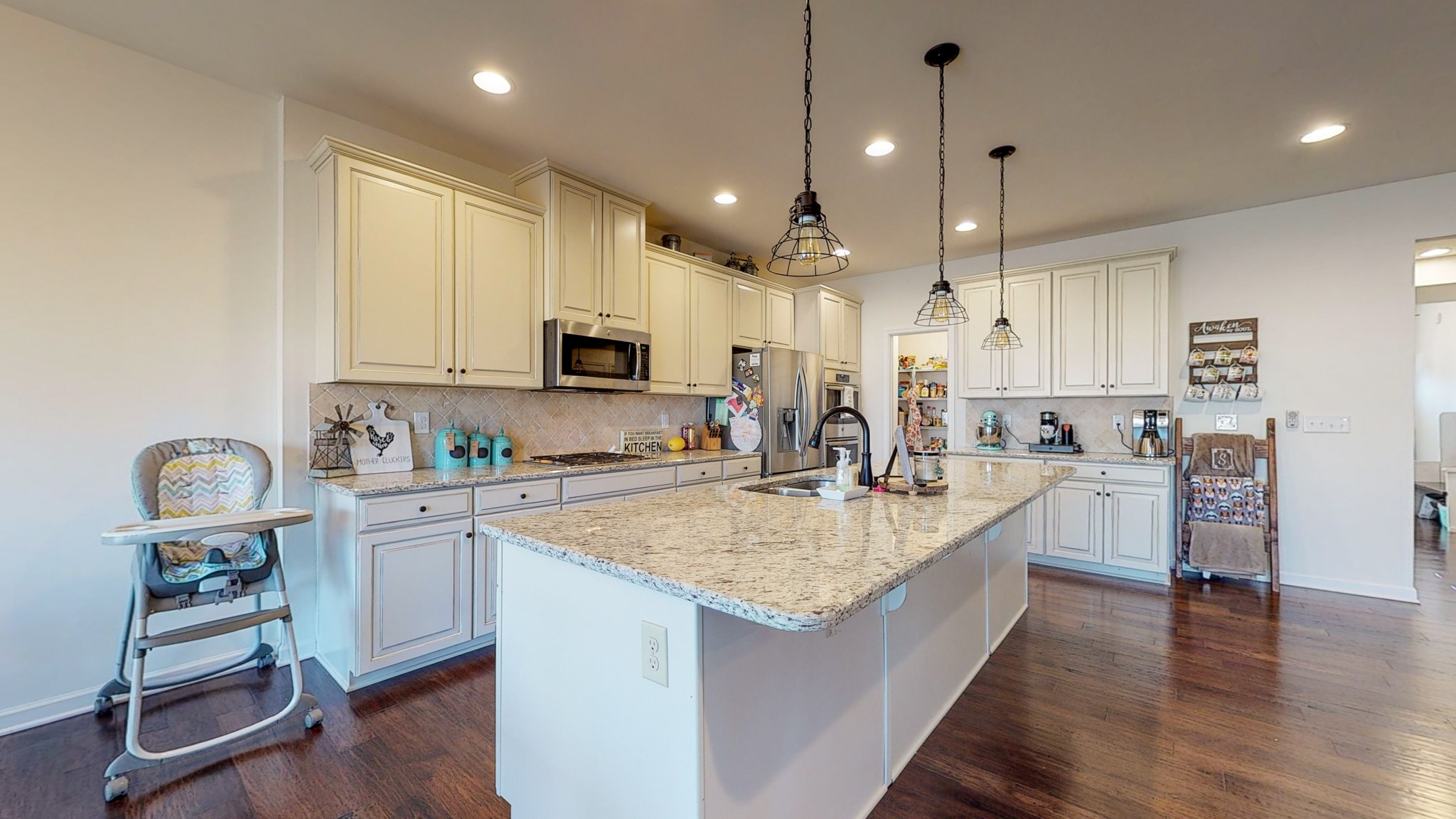 132 Hackney Lane Gallatin, TN 37066 - Photo 3 of 40 a large kitchen with kitchen island granite countertop a stove oven a sink dishwasher and white cabinets with wooden floor