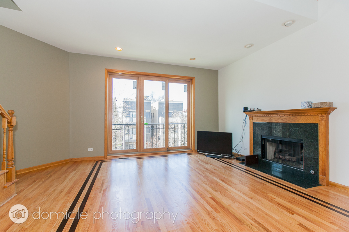 Undisclosed Address Chicago, IL 60618 - Photo 5 of 20 a living room with a fireplace and a floor to ceiling window