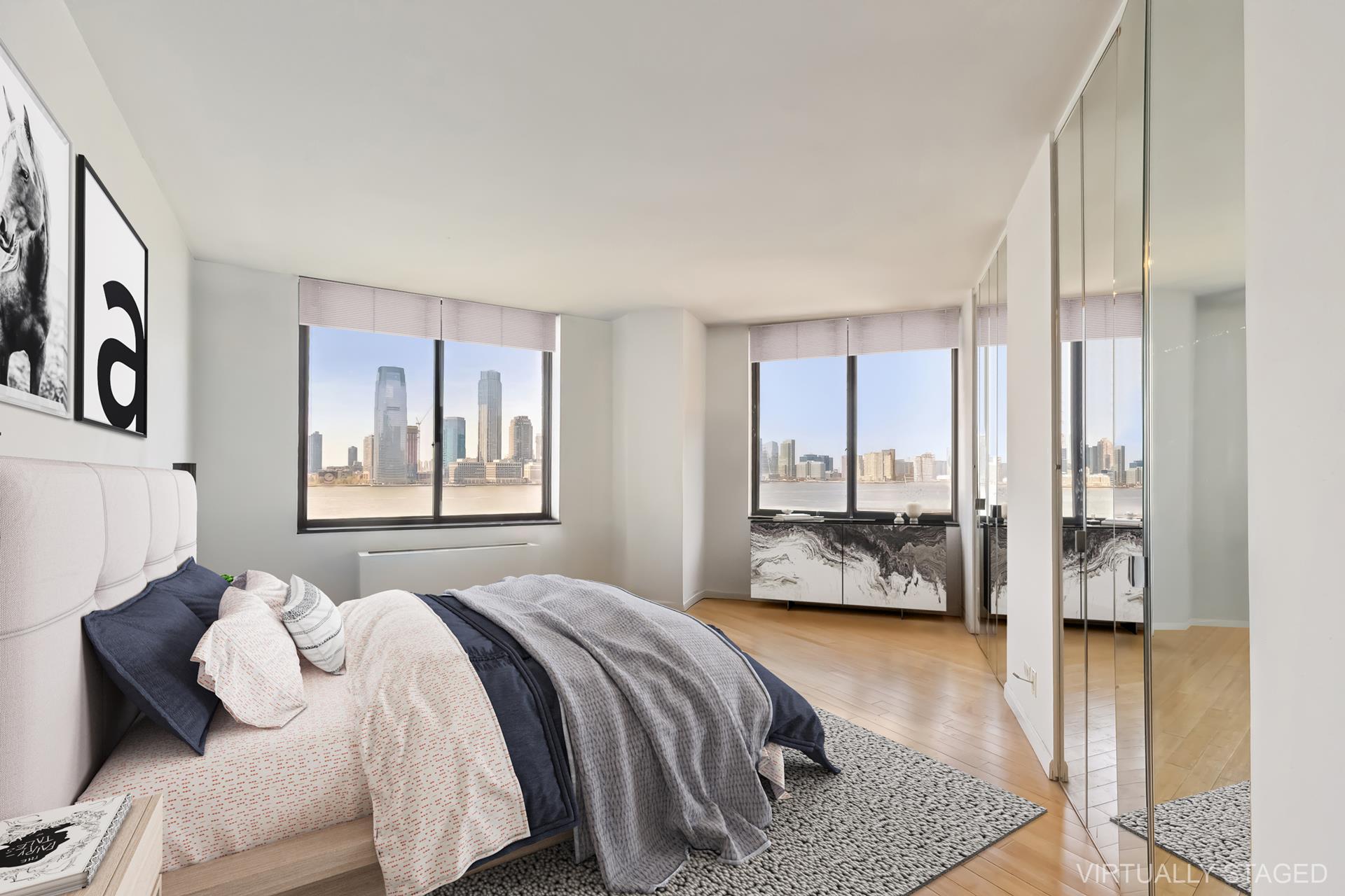 380 Rector Place, Unit 9J Manhattan, NY 10280 - Photo 1 of 7 a bedroom with a large bed and a couch