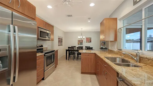 a kitchen with granite countertop a sink stove and refrigerator