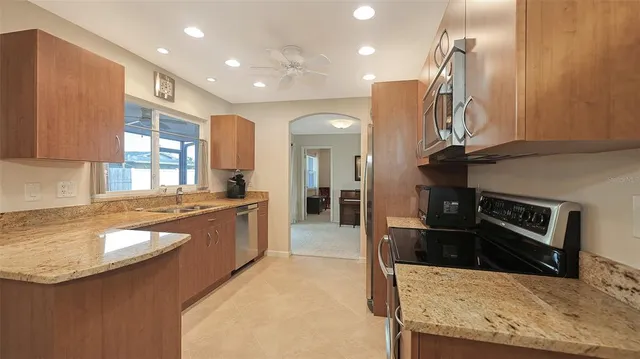a large kitchen with stainless steel appliances granite countertop a sink and a stove