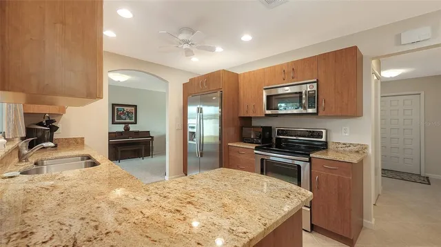 a kitchen with granite countertop a stove top oven and refrigerator