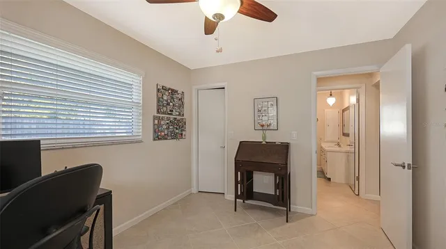 a view of a workspace with furniture and a window