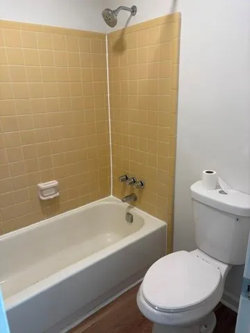 a white toilet sitting next to a bathtub