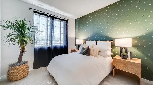 a bedroom with a large bed and a potted plant