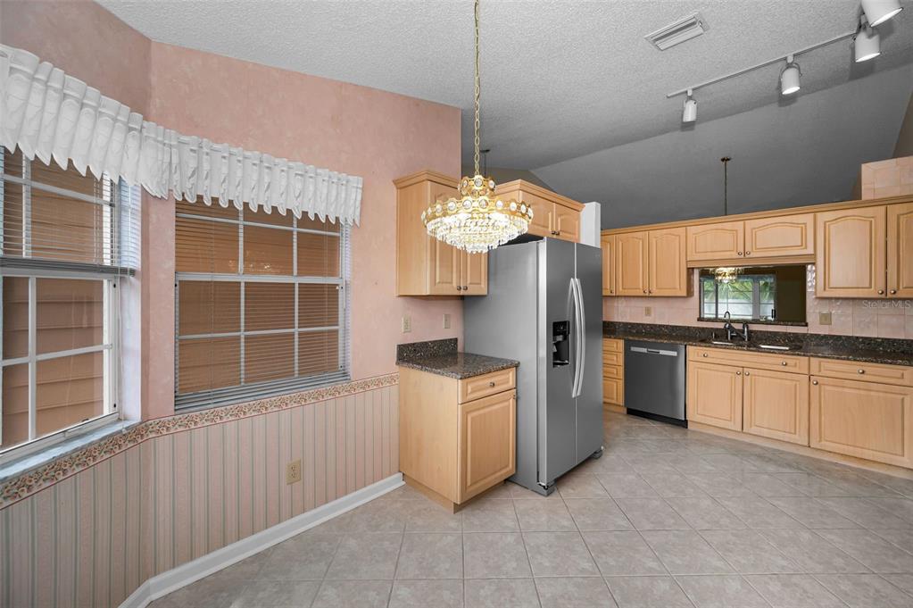 1481 Cairn Court Palm Harbor, FL 34683 - Photo 21 of 40 a kitchen with stainless steel appliances granite countertop a stove and a refrigerator
