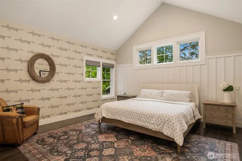 a bedroom with a bed and a wall painting