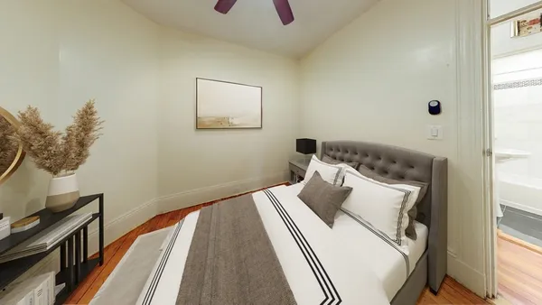 a bedroom with a bed and wooden floor