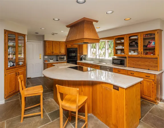 a kitchen with stainless steel appliances granite countertop a sink and a refrigerator