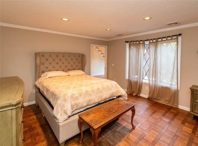 a bedroom with a bed and wooden floor
