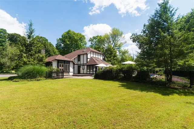 a front view of a house with yard and swimming pool