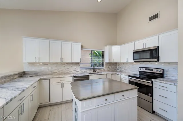 a kitchen with appliances a sink and cabinets