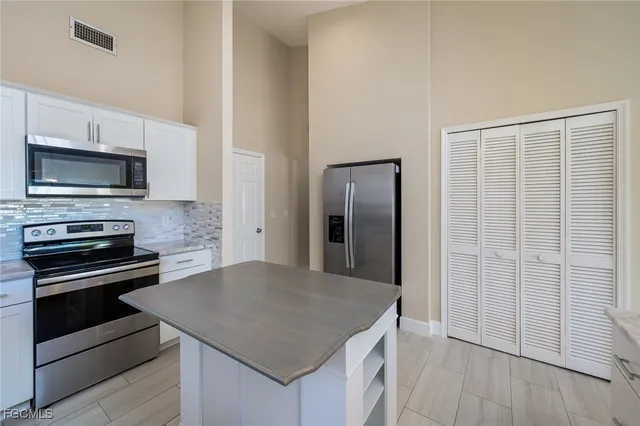 a kitchen with kitchen island a sink appliances and cabinets