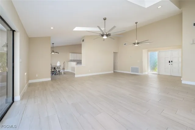an empty room with wooden floor and a ceiling fan