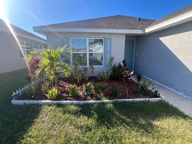 a front view of a house with a yard with potted plants