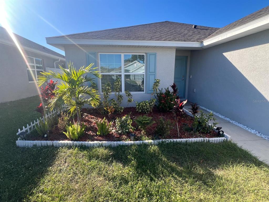 a front view of a house with a yard with potted plants