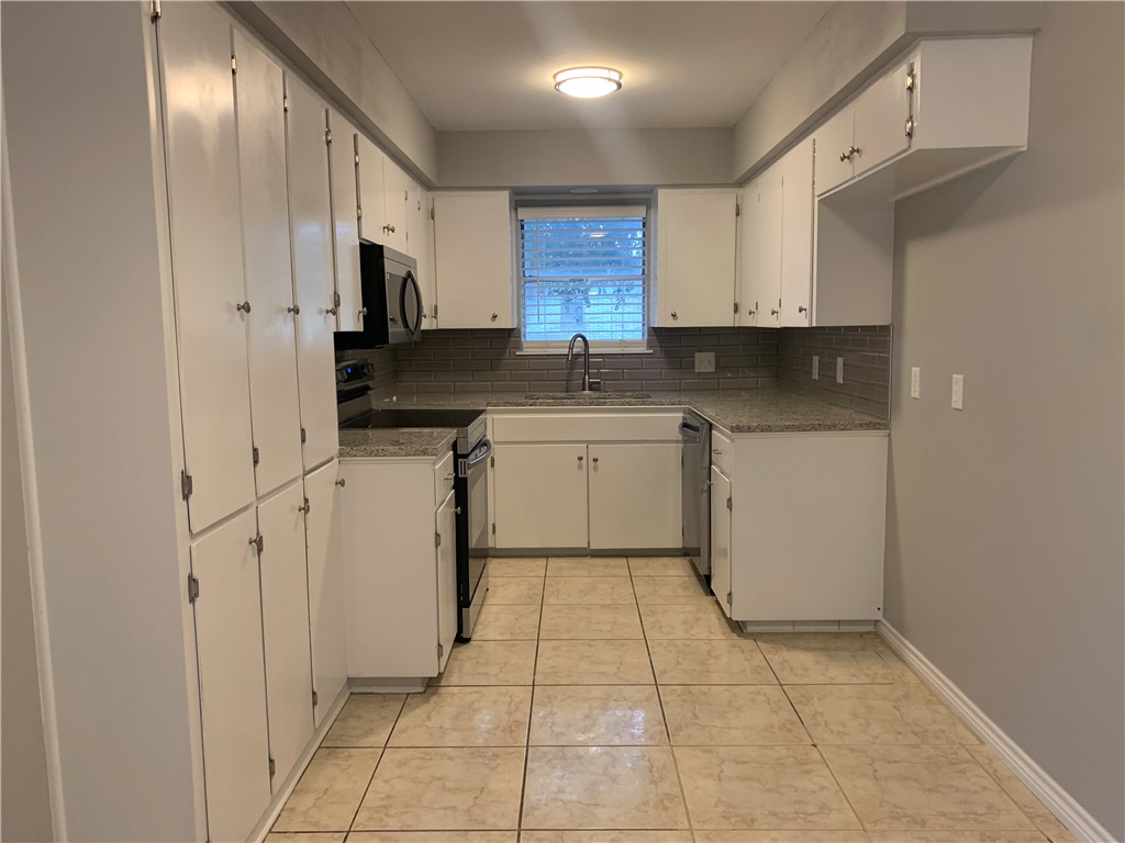1601 West Manor Drive Corpus Christi, TX 78411 - Photo 12 of 25 a kitchen with stainless steel appliances granite countertop a sink and cabinets