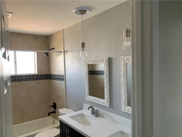 a bathroom with a sink mirror toilet and bathtub
