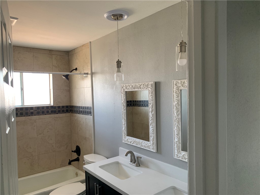 1601 West Manor Drive Corpus Christi, TX 78411 - Photo 14 of 25 a bathroom with a sink mirror toilet and bathtub