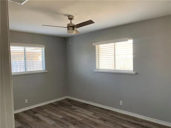 an empty room with a window and a fan