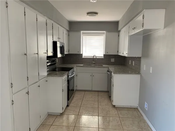 a kitchen with a sink stove and cabinets