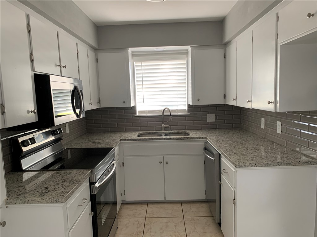 1601 West Manor Drive Corpus Christi, TX 78411 - Photo 9 of 25 a kitchen with granite countertop a sink stove and cabinets