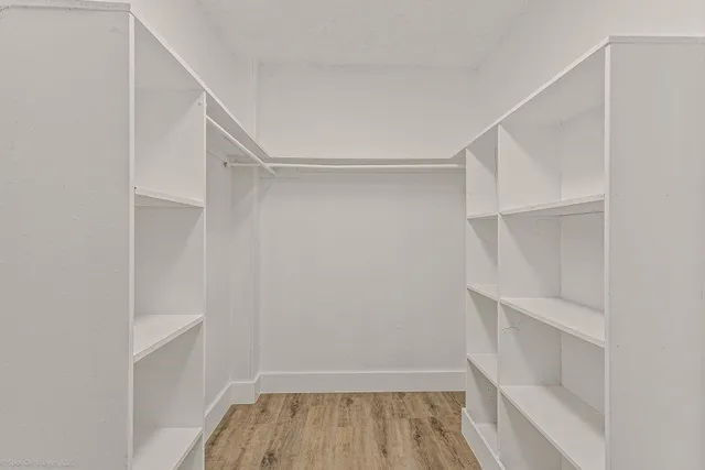 a view of walk in closet with empty racks