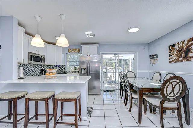 a kitchen with kitchen island a refrigerator and a stove top oven