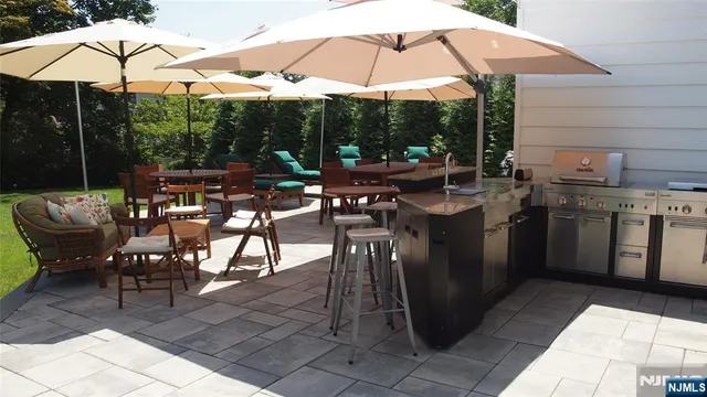 a view of a patio with chairs and umbrellas