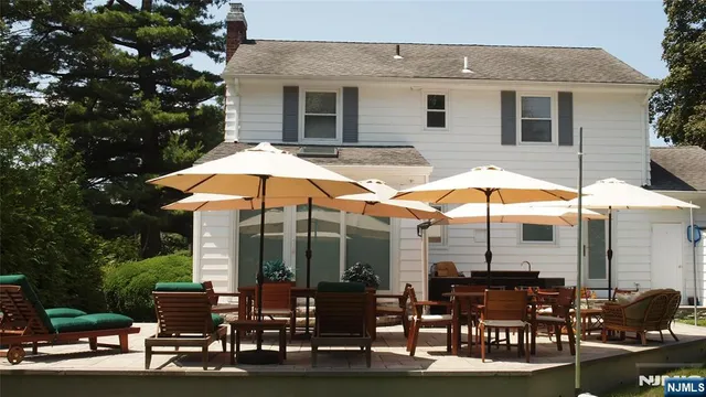 a patio with a table and chairs under an umbrella