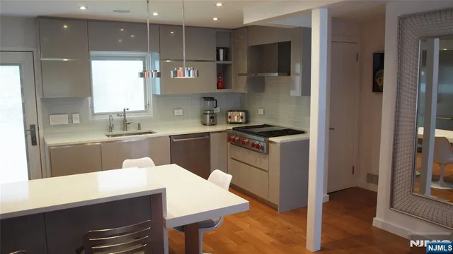 a kitchen with kitchen island a sink stainless steel appliances and cabinets