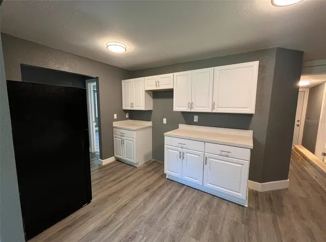 a kitchen with wooden floors and black appliances