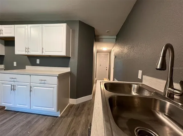 a kitchen with a refrigerator sink and cabinets