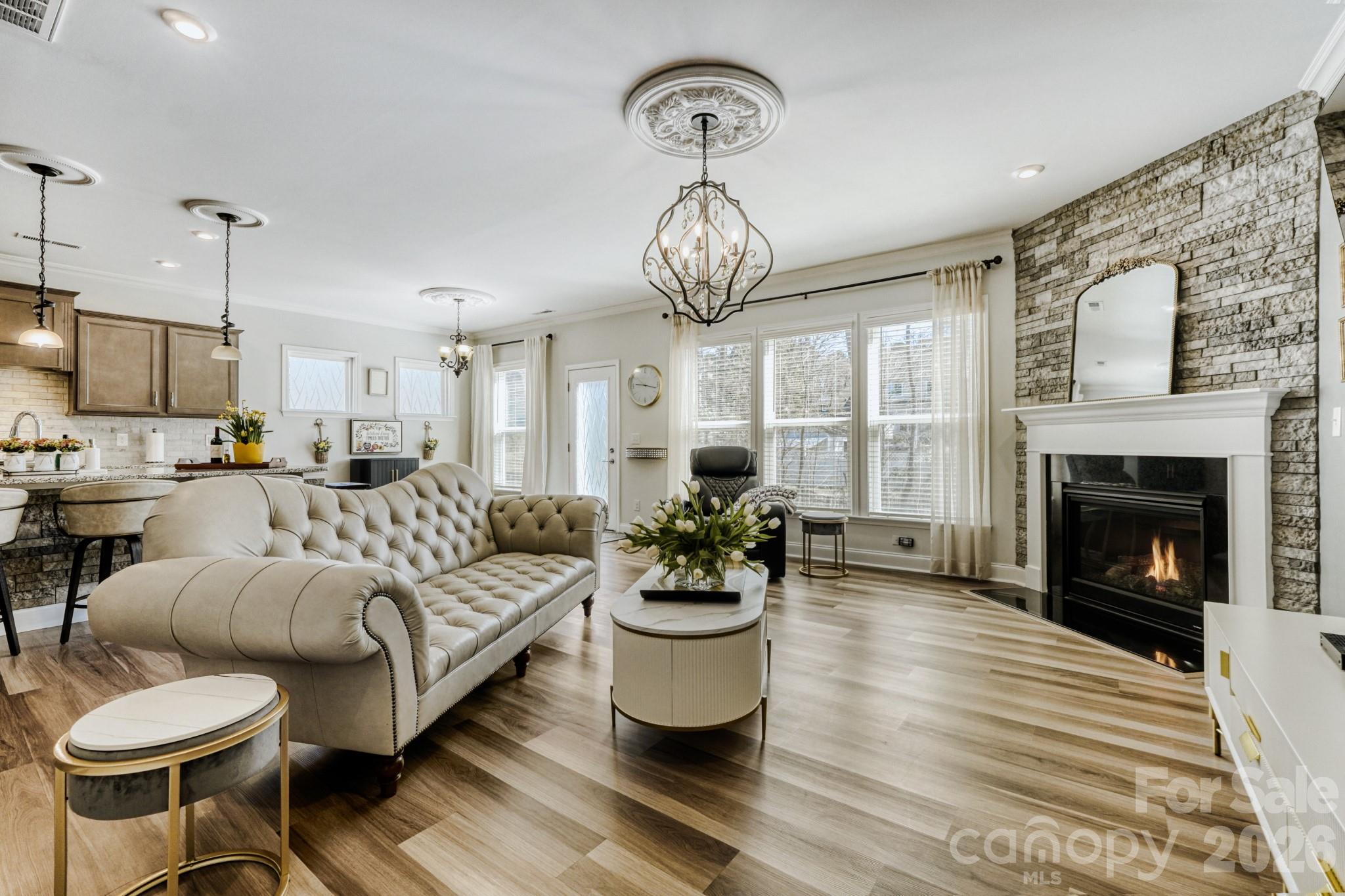 1318 Poppy Way Matthews, NC 28104 - Photo 6 of 33 a living room with furniture a chandelier and a fireplace