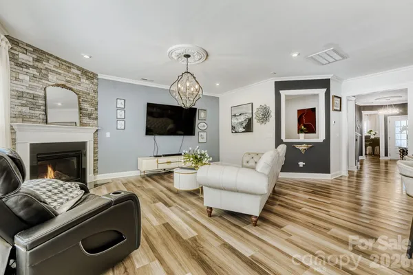 a kitchen with stainless steel appliances granite countertop a kitchen island hardwood floor sink stove dining table and chairs