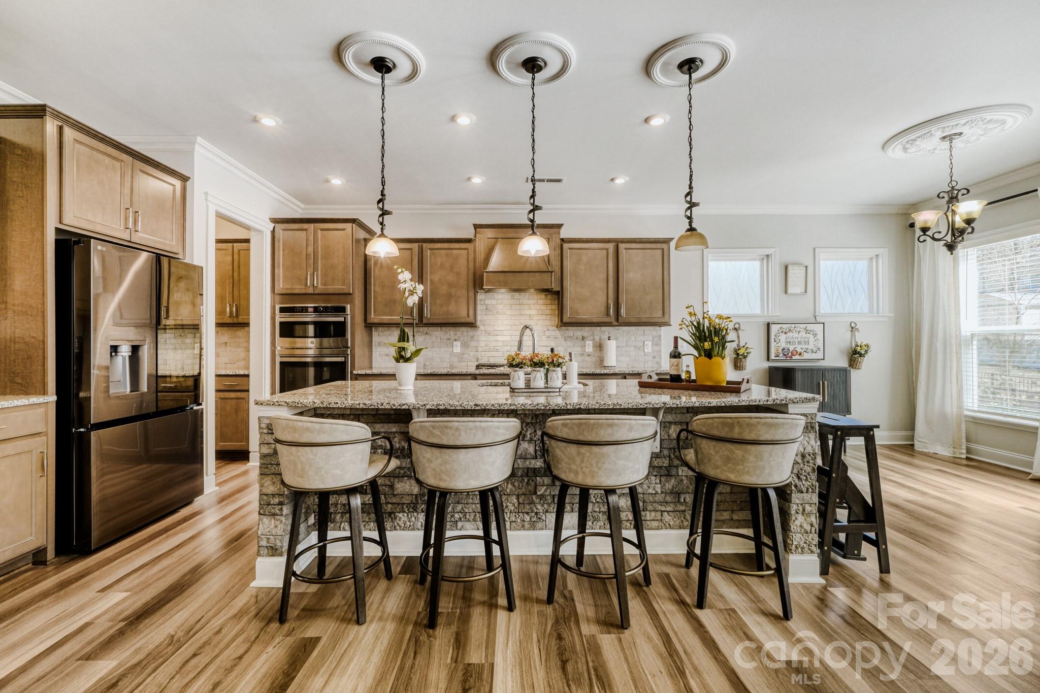 1318 Poppy Way Matthews, NC 28104 - Photo 9 of 33 a kitchen with stainless steel appliances a dining table chairs and granite counter tops