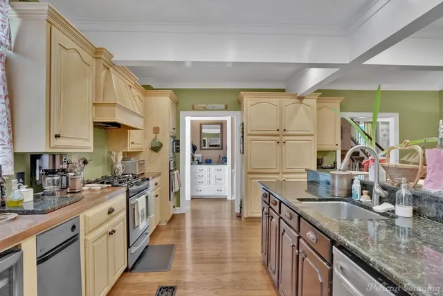 a kitchen with stainless steel appliances granite countertop a sink stove and refrigerator