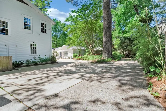 a white house that has tree in front of it