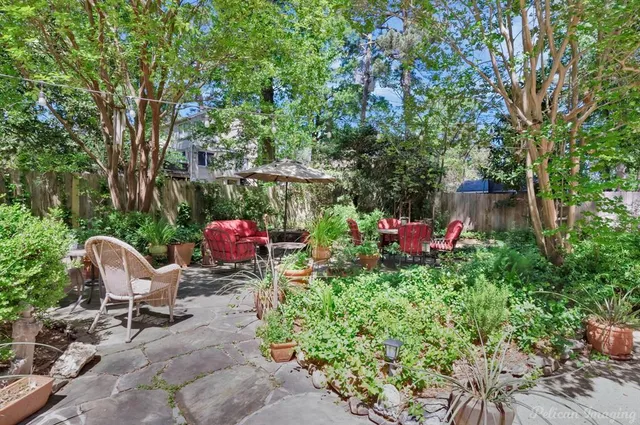 a backyard of a house with table and chairs and potted plants