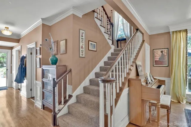 a view of staircase with lots of frames on wall and wooden floor