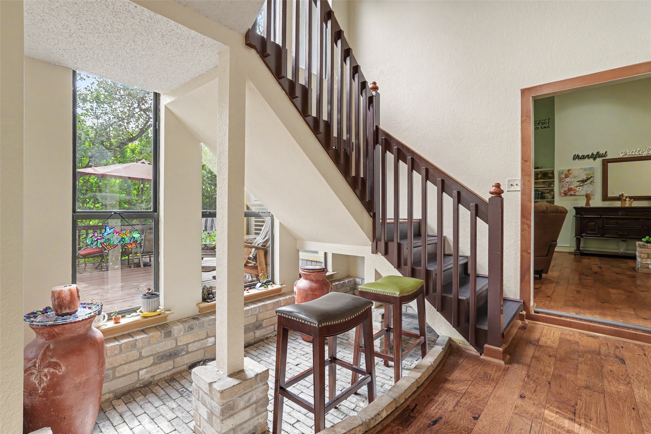 110 South Ridge Circle Georgetown, TX 78628 - Photo 14 of 37 Hardwood flooring entry with dark wood staircase featuring a brick-lined lower level and tall windows