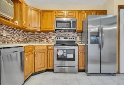 a kitchen with stainless steel appliances granite countertop a refrigerator and a stove top oven