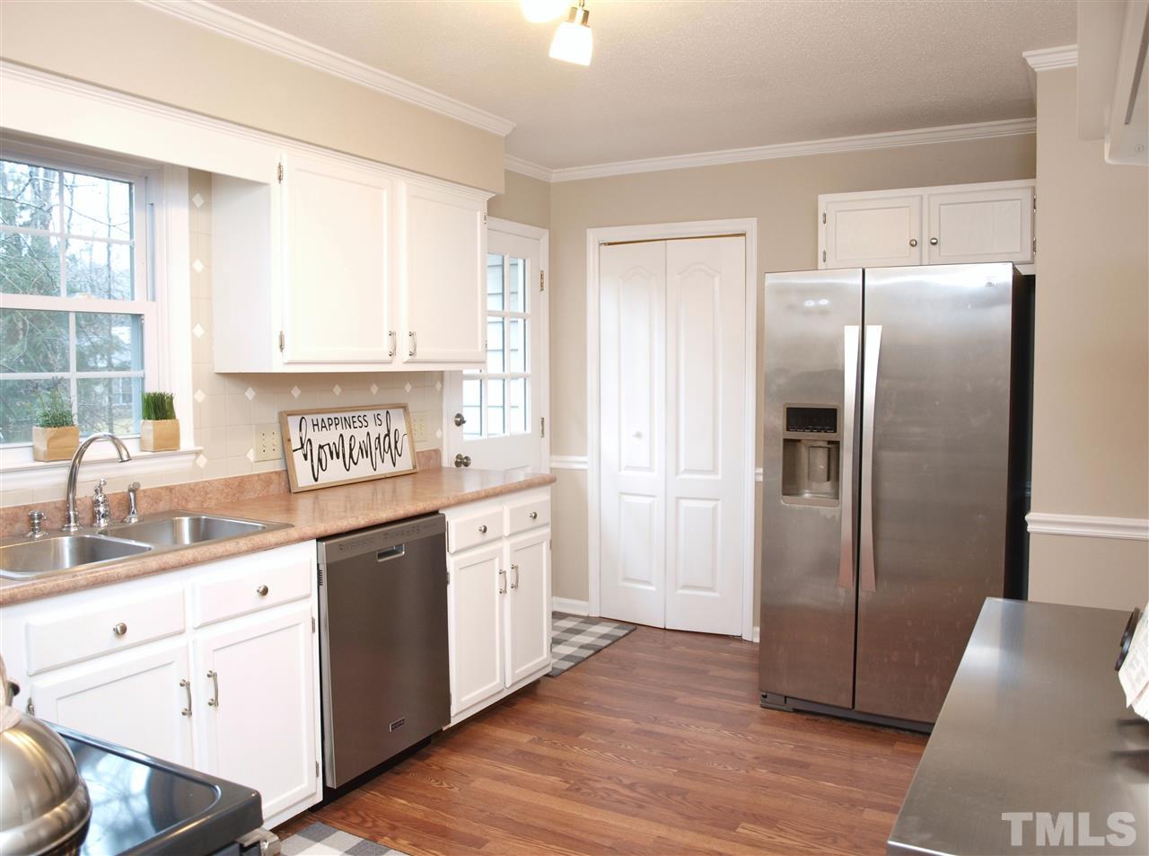 1117 Toppe Ridge Court Raleigh, NC 27615 - Photo 3 of 30 a kitchen with granite countertop a refrigerator sink and cabinets